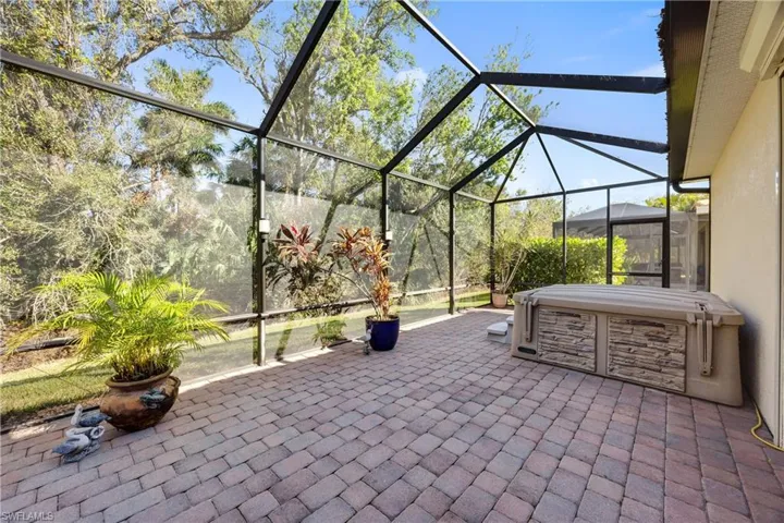 View of patio / terrace with glass enclosure and a hot tub