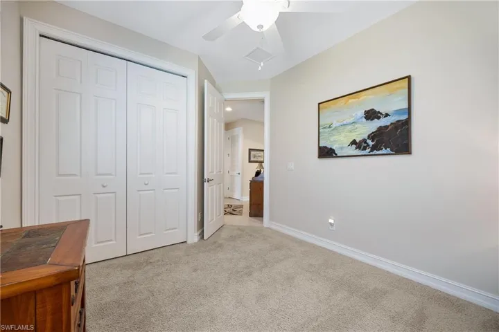 Bedroom with light carpet, a closet, and ceiling fan