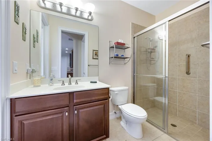 Bathroom with tile patterned flooring, vanity, toilet, and a shower with shower door