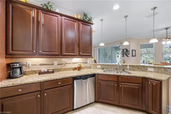 Kitchen with ceiling fan, dishwasher, sink, crown molding, and pendant lighting