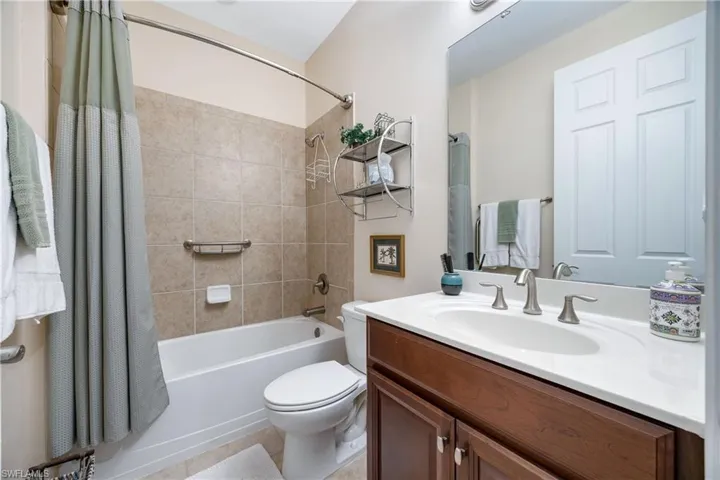 Full bathroom with tile patterned floors, shower / bath combo, toilet, and vanity