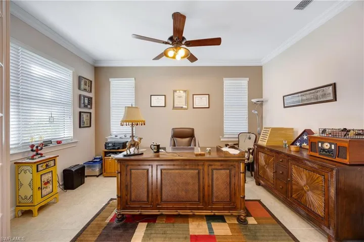 Tiled office with ceiling fan and ornamental molding