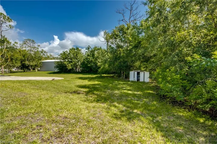 View of grassy yard with a storage shed
