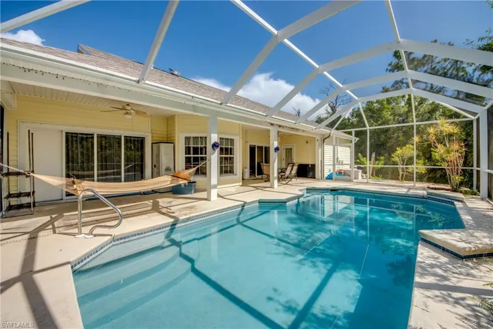 Swimming pool with a patio, ceiling fan, and a lanai