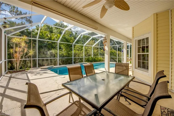 View of patio with ceiling fan, an outdoor pool, a lanai, and outdoor dining space