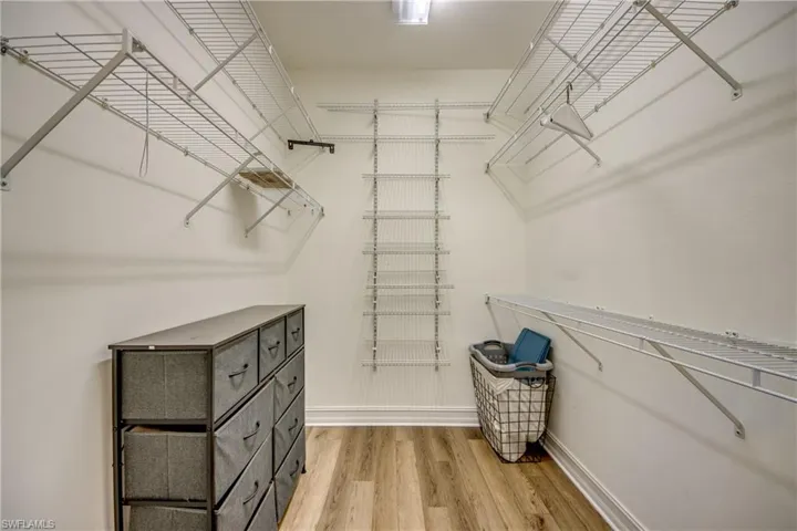 Walk in closet with light wood finished floors