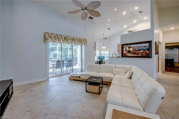 Living area featuring a ceiling fan, high vaulted ceiling, recessed lighting, and light tile patterned floors