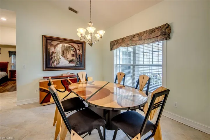 Dining space with a chandelier, lofted ceiling, and light tile patterned floors