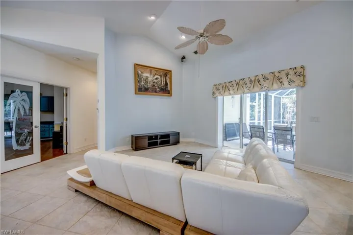 Living area featuring light tile patterned flooring, a ceiling fan, and high vaulted ceiling