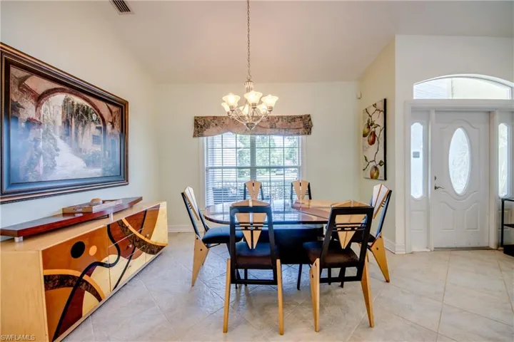 Dining space featuring a chandelier, lofted ceiling, and light tile patterned flooring