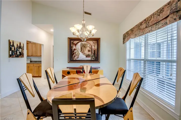 Dining room with a chandelier, lofted ceiling, and light tile patterned floors