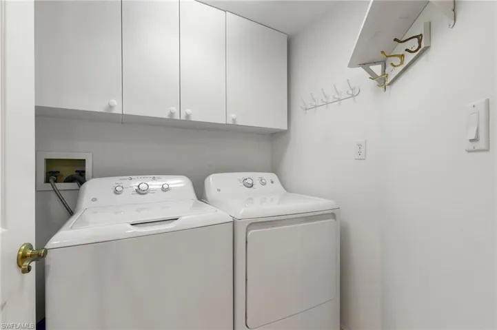 Separate laundry room with above cabinets