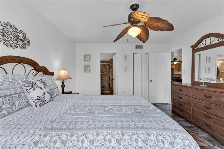 Primary bedroom with ensuite bath, walk-in closet, and sliders to screen lanai