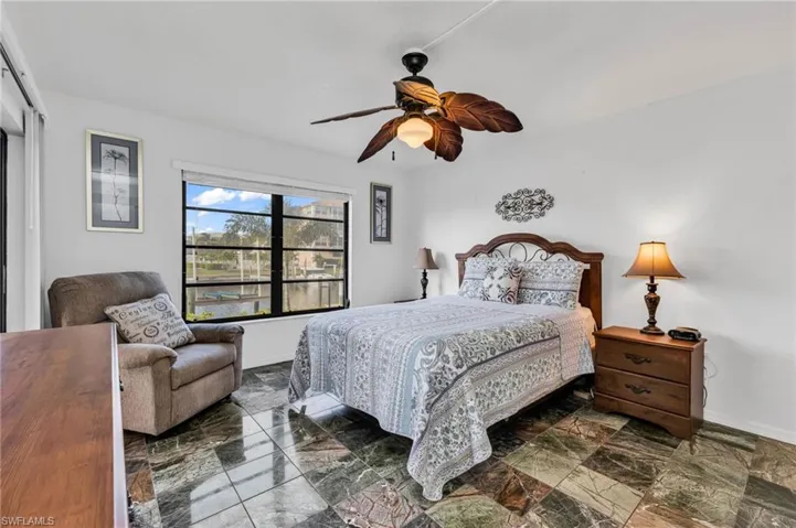 Primary bedroom with ensuite bath, walk-in closet, and sliders to screen lanai