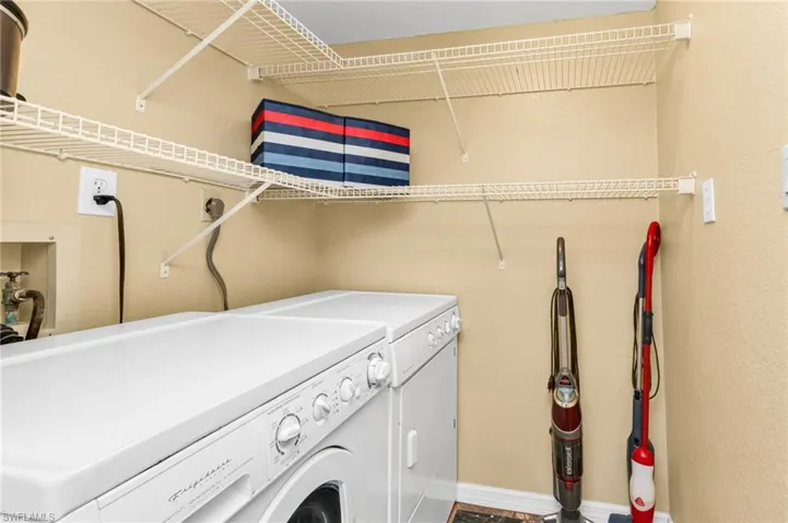 Interior laundry room with storage shelves. Washer & Dryer convey.