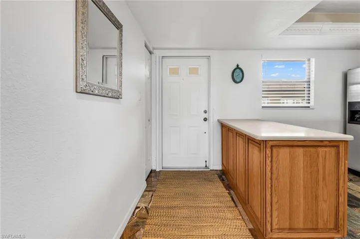 Entry hallway facing door, with kitchen on right