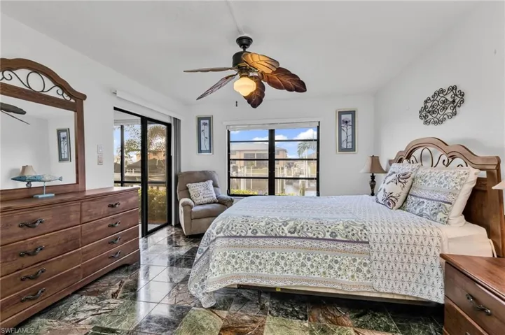 Primary bedroom with ensuite bath, walk-in closet, and sliders to screen lanai