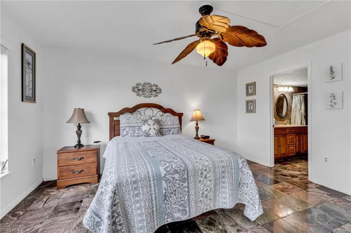 Primary bedroom with ensuite bath, walk-in closet, and sliders to screen lanai
