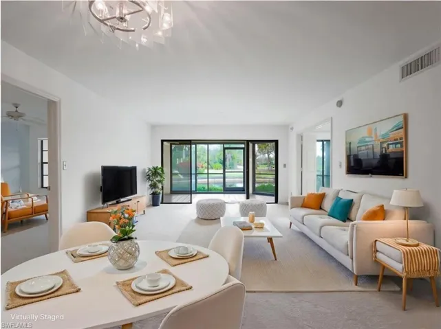 Livingroom featuring light carpet,ceiling fan and hanging light