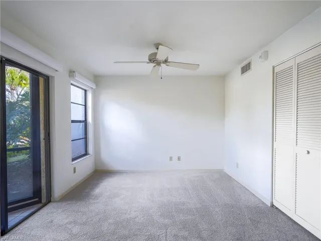 Unfurnished office/bedroom with light colored carpet, access to exterior, ceiling fan, and a closet