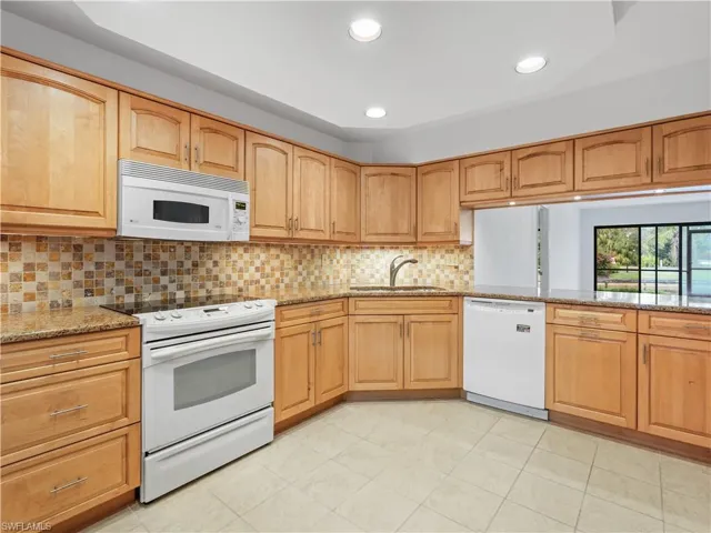 Kitchen featuring light stone countertops, recessed lighting, decorative backsplash, and light tile patterned flooring