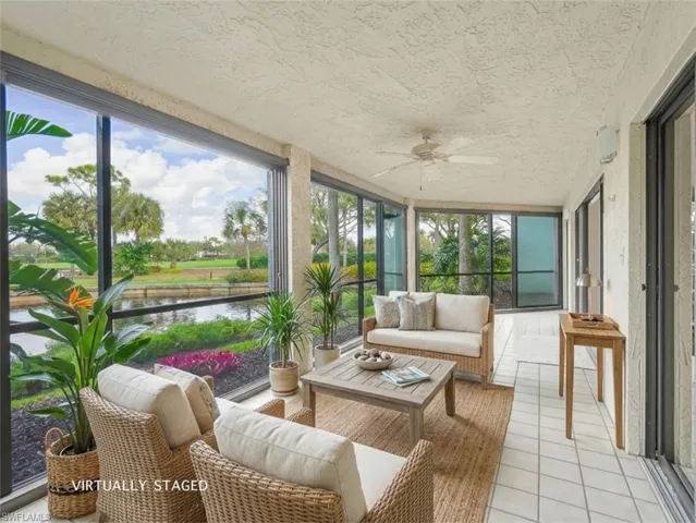 Sunroom with outdoor furniture, tile patterned flooring, a ceiling fan, floor to ceiling windows, and a water view
