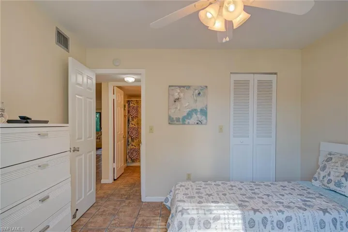 Tiled bedroom with a closet and a ceiling fan