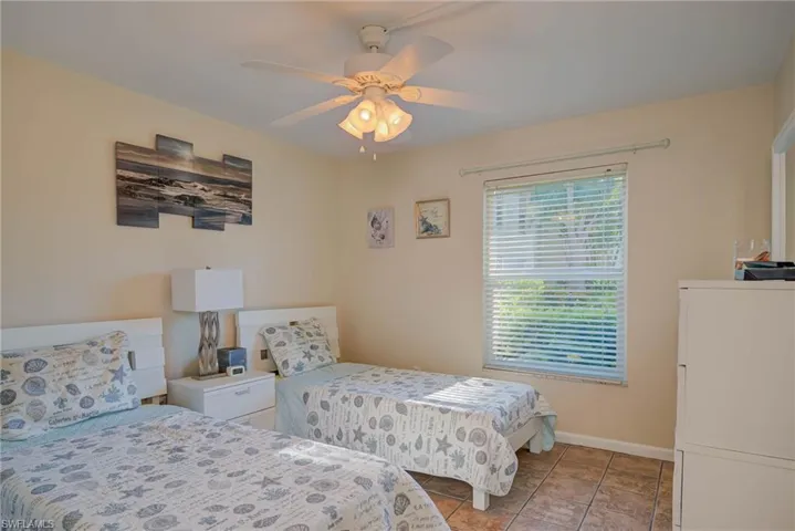 Bedroom with ceiling fan and light tile patterned flooring