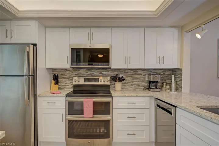 Kitchen featuring stainless steel appliances and white cabinets