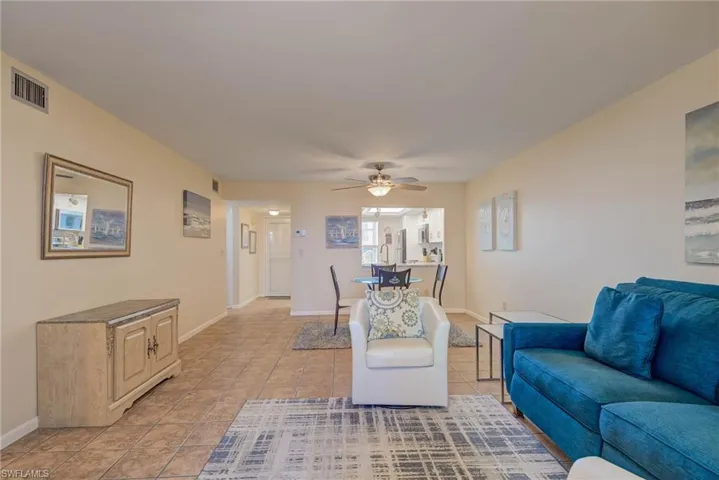 Living area featuring light tile patterned floors and a ceiling fan