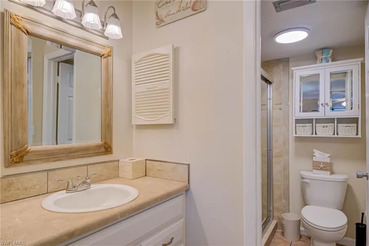 Bathroom featuring a shower stall, vanity, and light tile patterned floors