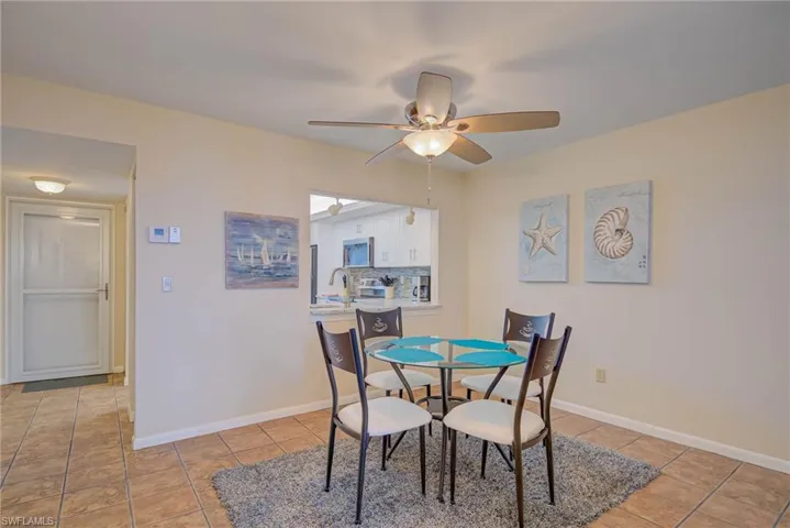 Dining space with light tile patterned floors and a ceiling fan