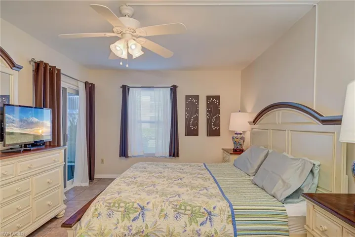 Bedroom with a ceiling fan, light tile patterned flooring, and access to outside
