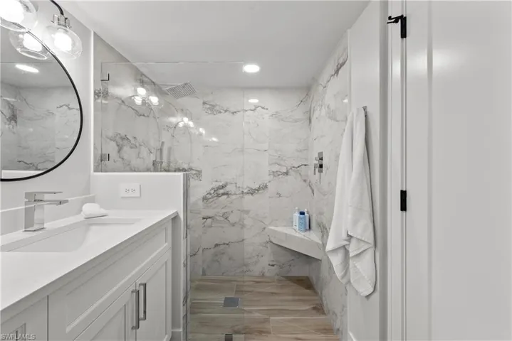 Full bathroom with a marble finish shower, vanity, and recessed lighting