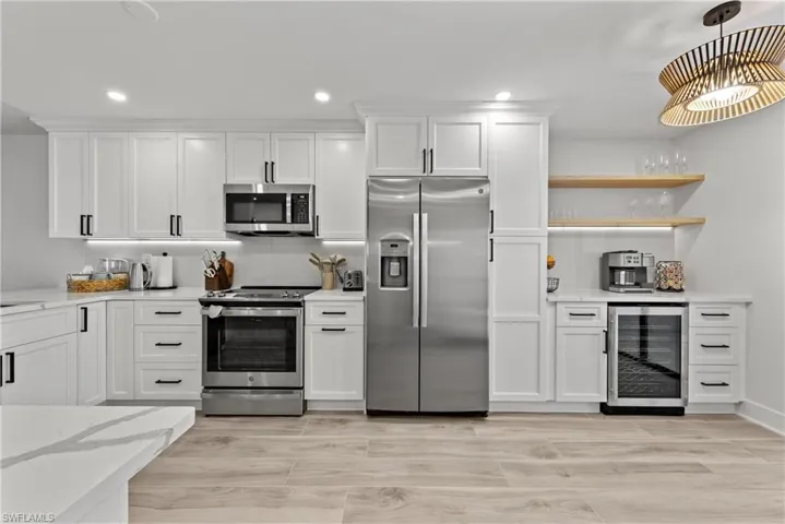 Kitchen featuring stainless steel appliances, open shelves, beverage cooler, white cabinetry, and recessed lighting