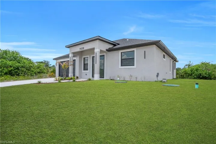 Contemporary single-story residence featuring a stucco exterior, dark shingle roof, and a concrete driveway
