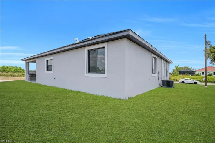 Contemporary single-story residence featuring light gray stucco exterior and dark trim windows