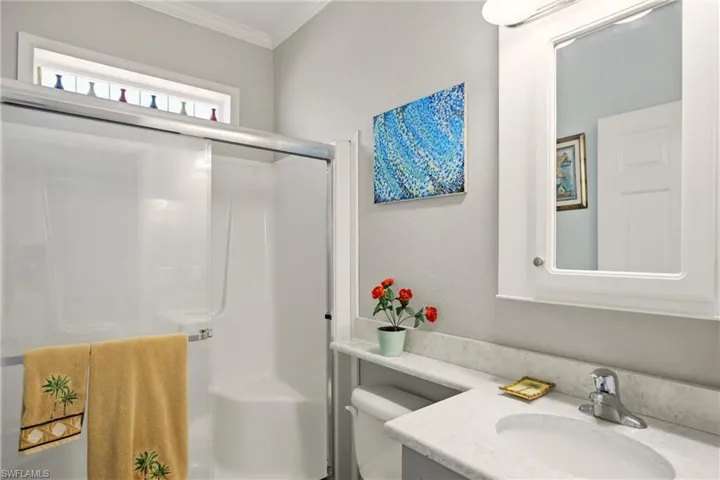 Bathroom with vanity, a stall shower, ornamental molding, and a textured wall