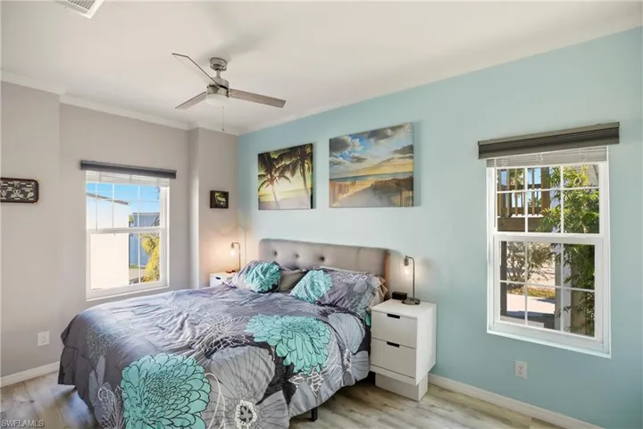 Bedroom featuring wood finished floors, ceiling fan, and ornamental molding