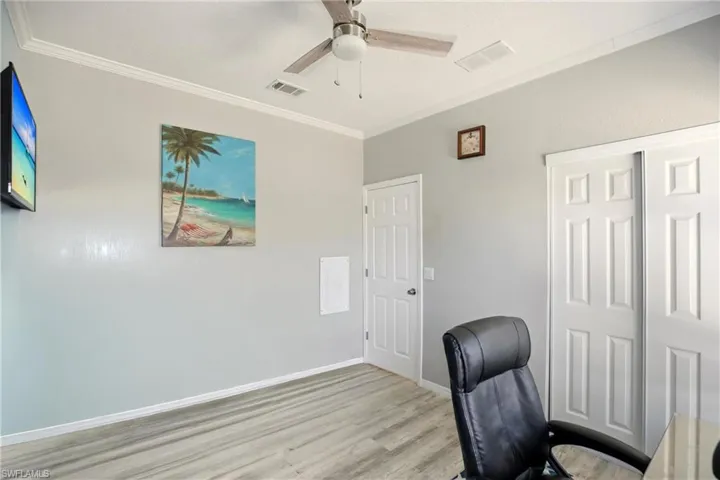 Office with ornamental molding, wood finished floors, and ceiling fan