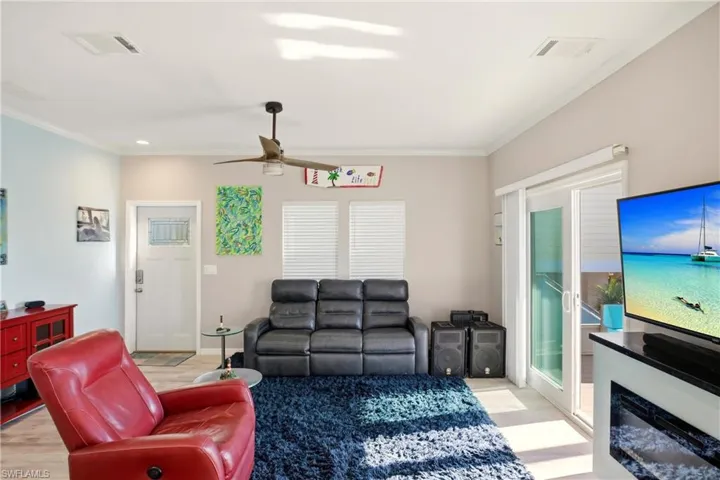 Living room featuring light wood-style flooring, ornamental molding, ceiling fan, and recessed lighting