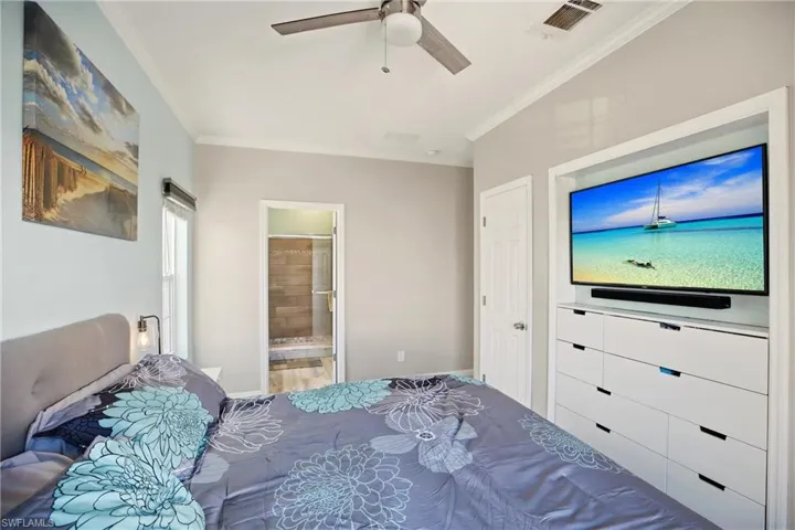 Bedroom featuring crown molding, a ceiling fan, and ensuite bathroom