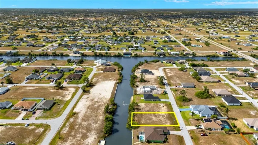 Aerial perspective of suburban area with property boundaries highlighted and a nearby body of water