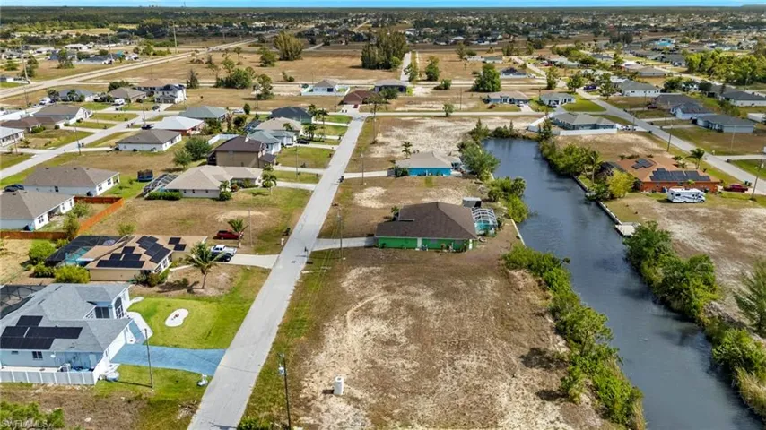Aerial view of property and surrounding area with a large body of water and nearby suburban area