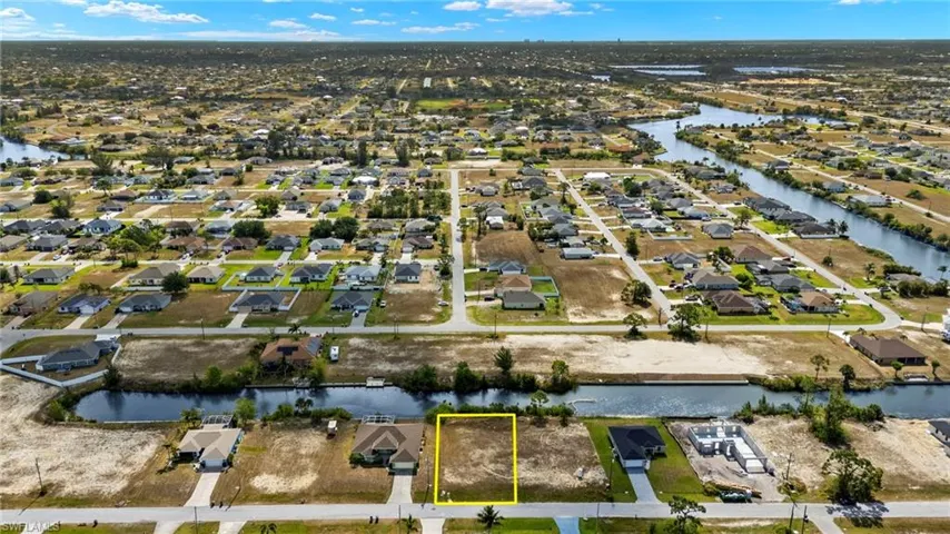 Aerial perspective of suburban area with a large body of water and property parcel outlined