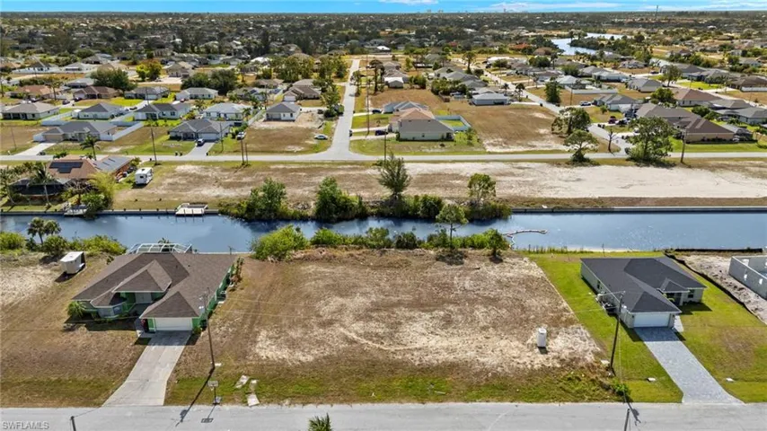 Aerial perspective of suburban area featuring a nearby body of water