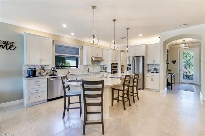 Kitchen featuring pendant lighting, plenty of natural light, a kitchen island, and appliances with stainless steel finishes