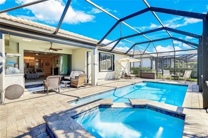 View of swimming pool featuring a patio area, ceiling fan, and a lanai
