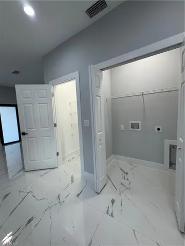 Clothes washing area featuring electric dryer hookup and hookup for a washing machine