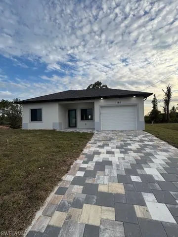 Ranch-style home with a front yard and a garage